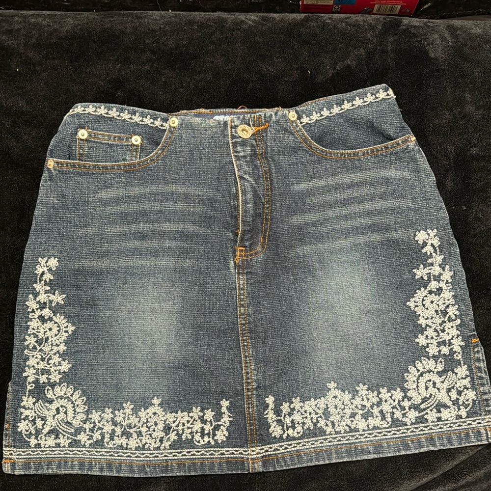 STONE jean mini skirt with brown stitching and baby blue embroidery.Style 05547